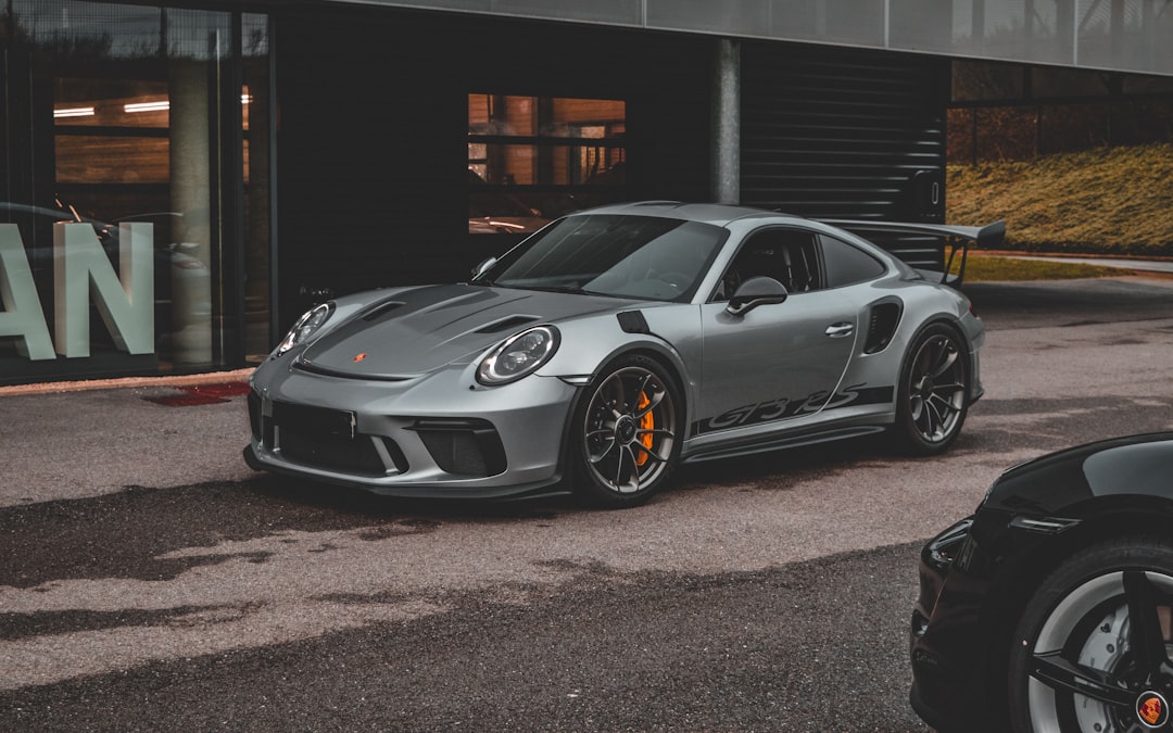 Une Porsche GTR grise garée devant un bâtiment