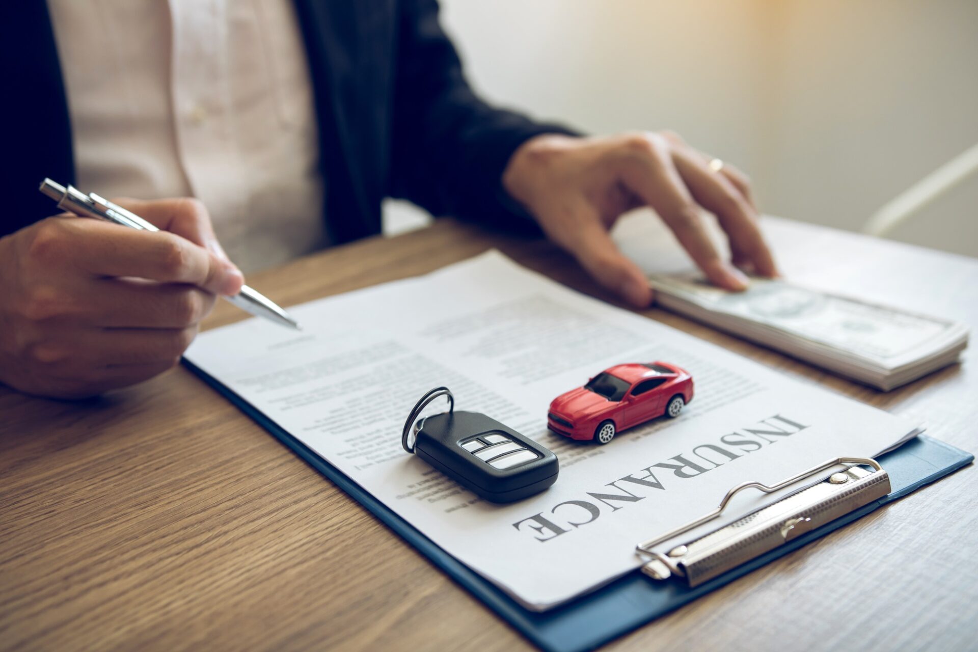 L'agent signe le contrat d'assurance pour la voiture au document sur le bureau.