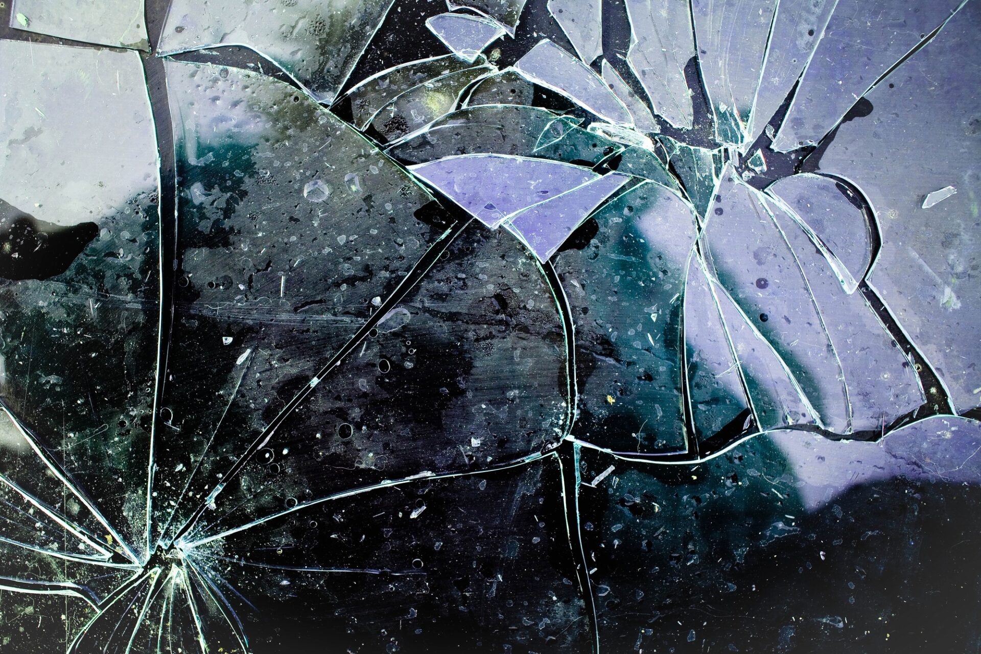 Détail du verre brisé sur fond noir.