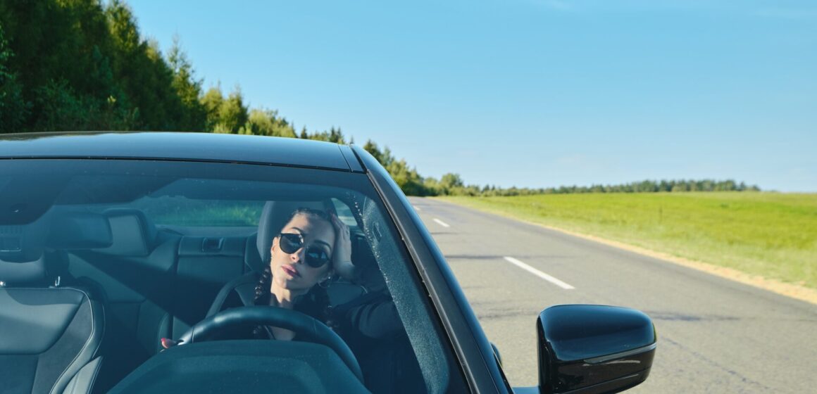 power-car Jolie femme conduisant une voiture puissante sur une route de campagne