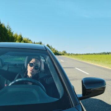 power-car Jolie femme conduisant une voiture puissante sur une route de campagne