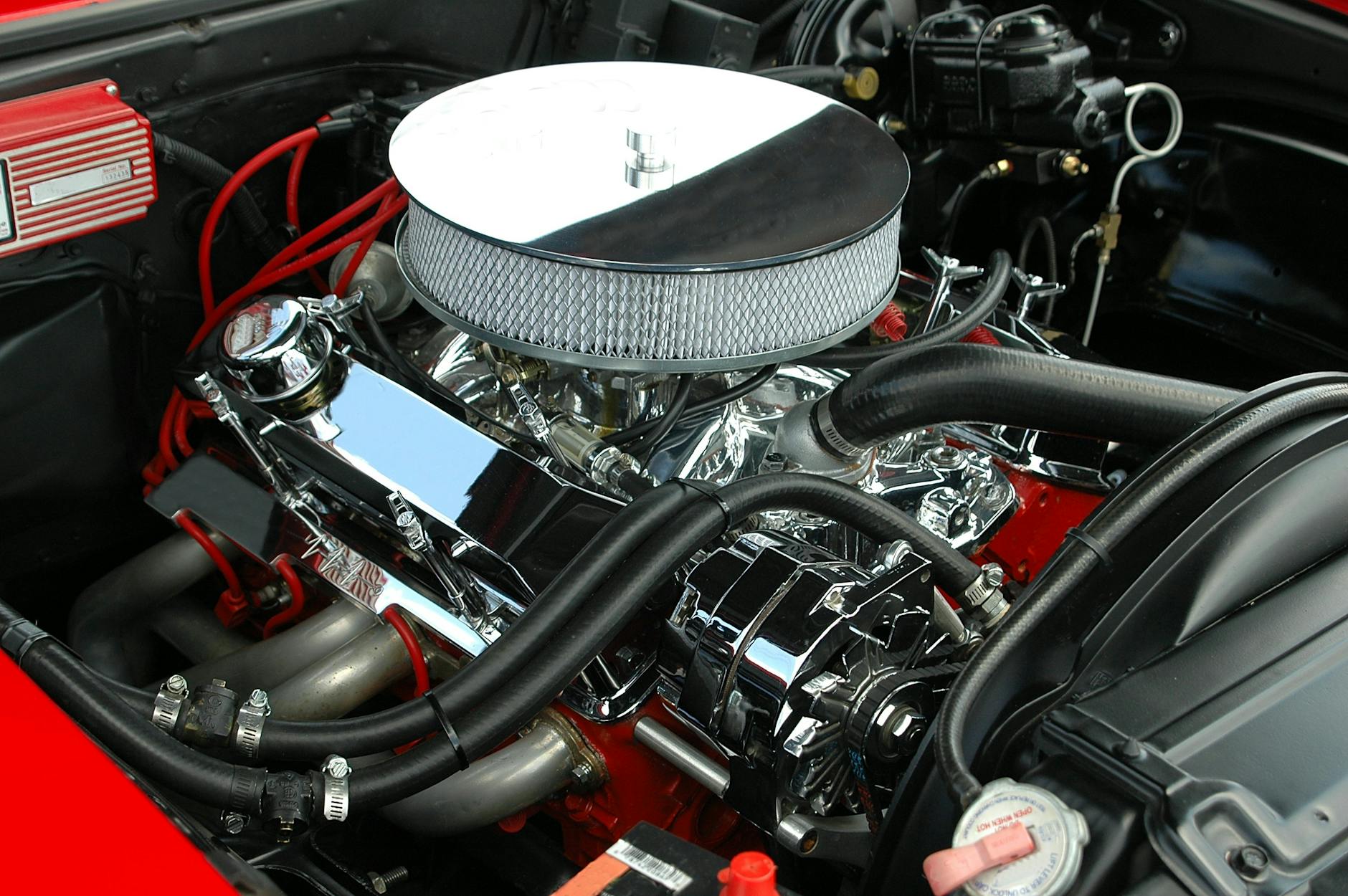Vue détaillée d'un moteur de voiture polie et haute performance présentant des détails chromés et des mécanismes complexes.