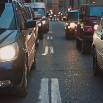 cars-2 Une rue encombrée bordée de voitures coincées dans la circulation au crépuscule, mettant en valeur la vie urbaine.
