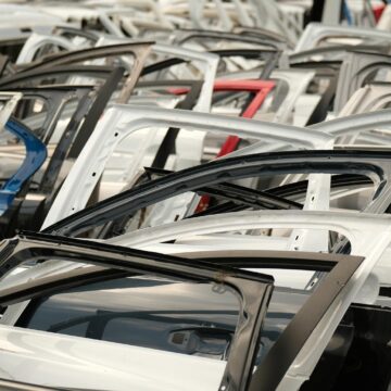 parts-auto Une variété de portes de voiture de différentes couleurs disposées dans un décor de casse.
