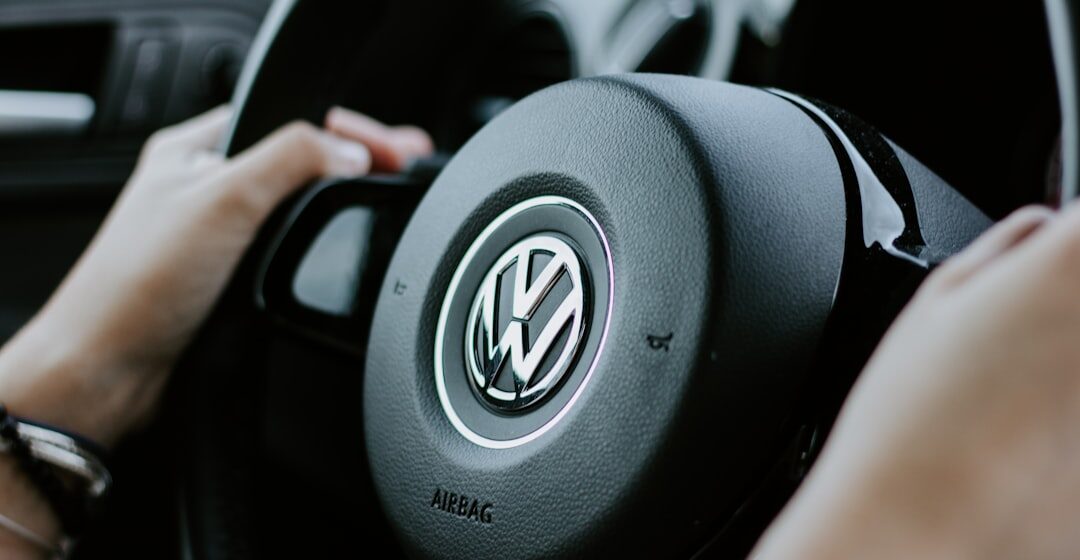 Volkswagen personne tenant un volant Volkswagen noir en photo en gros plan