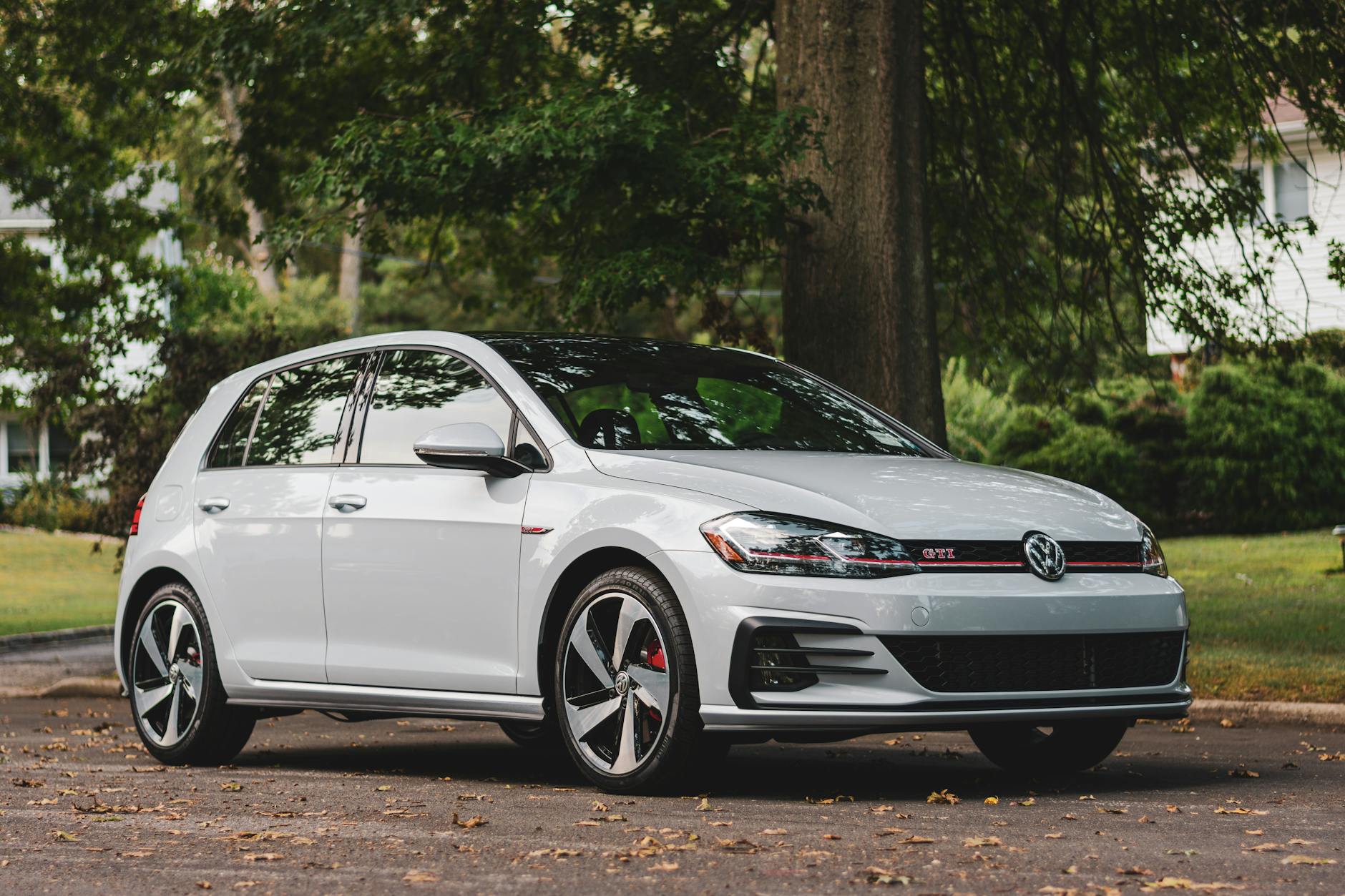 Volkswagen GTI blanche garée dans un cadre extérieur pittoresque, mettant en valeur un design moderne.