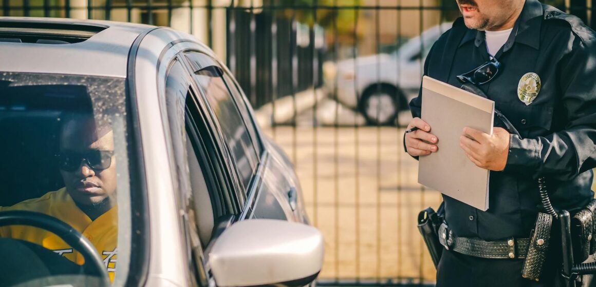 car-fine Agent de police à la fenêtre d'une voiture délivrant une contravention à un conducteur dans un cadre extérieur ensoleillé.