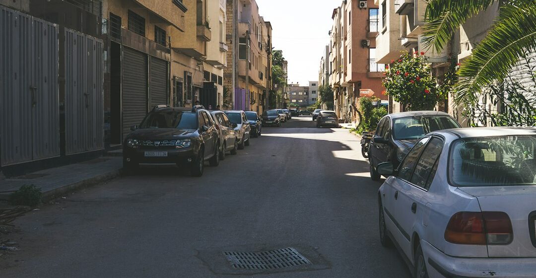 Location-voiture-Maroc Voitures garées dans une rue d’une ville.