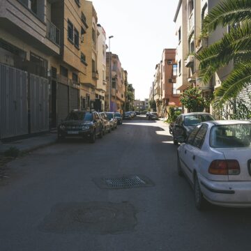 Location-voiture-Maroc Voitures garées dans une rue d’une ville.