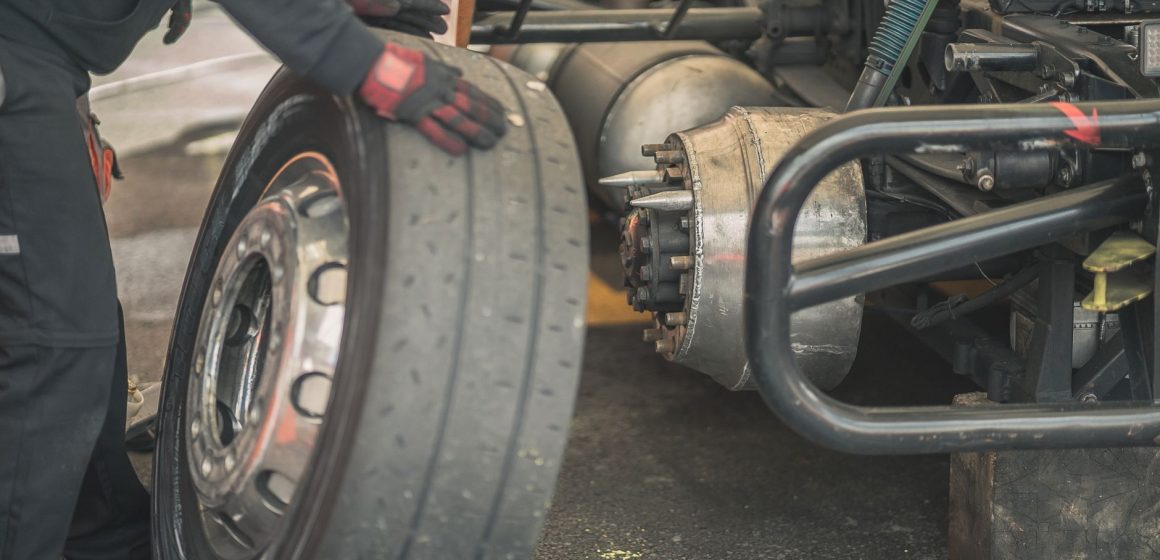 pneus-poids-lourds Un mécanicien travaille au remplacement d'un pneu dans un garage automobile professionnel.